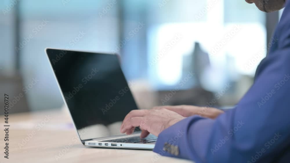 Rear View of Young Businessman using Laptop Rear View of Young Businessman using Laptop
