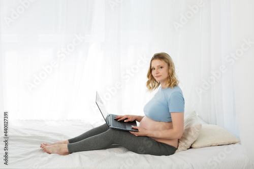 Blonde pregnant woman working on a computer