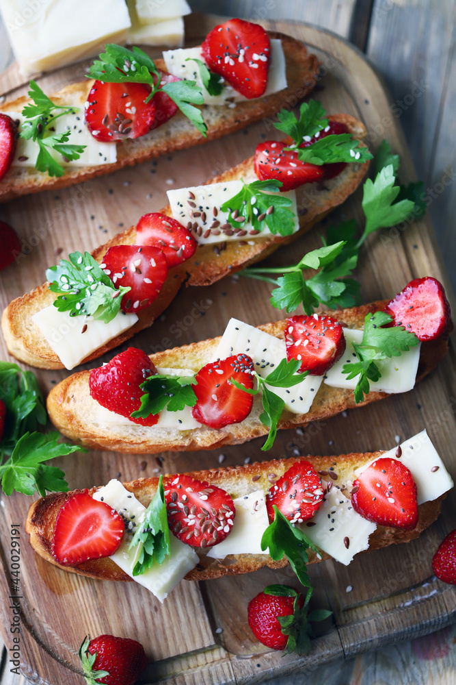 Beautiful bruschetta with strawberries and cheese. Strawberry toast. Healthy summer food.
