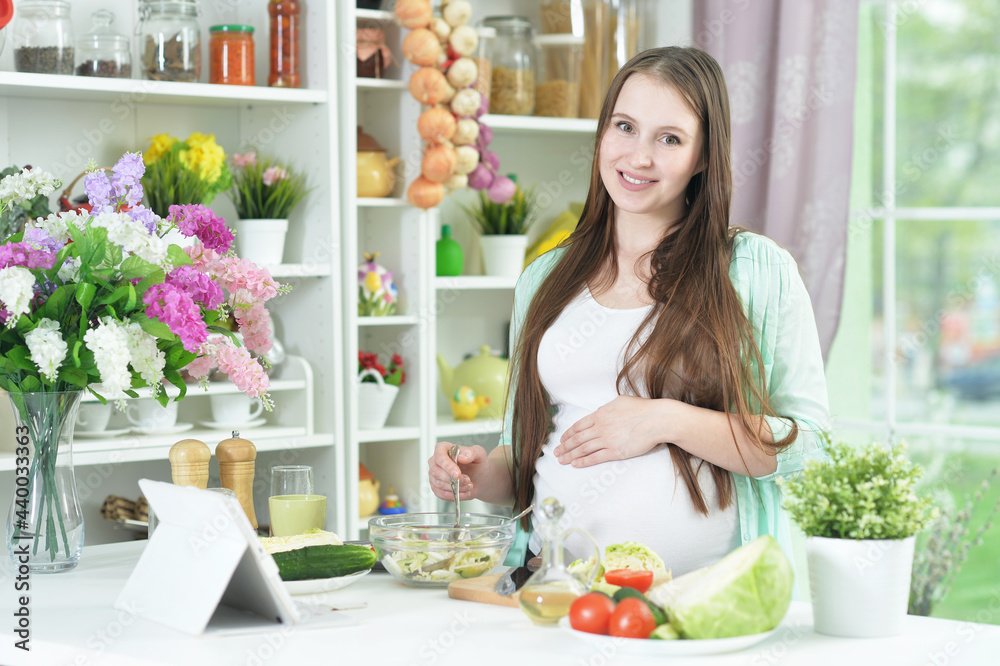 beautiful pregnant  young woman cooking  in kitchen