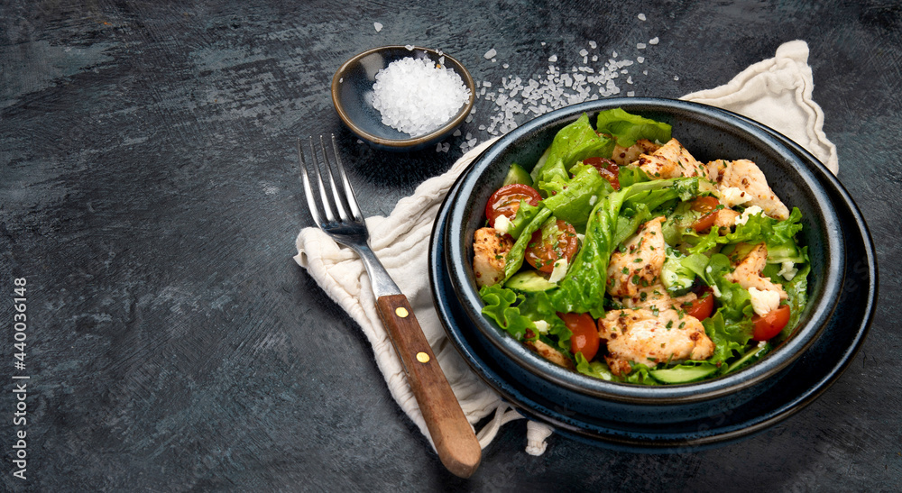 Fresh chicken salad on drak gray background. Healthy food concept.