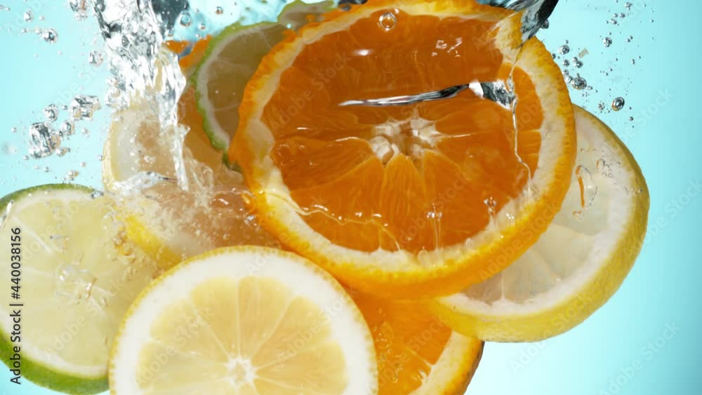 Super slow motion of falling lime, orange and lemon slices into water. Filmed on high speed cinema camera, 1000 fps.