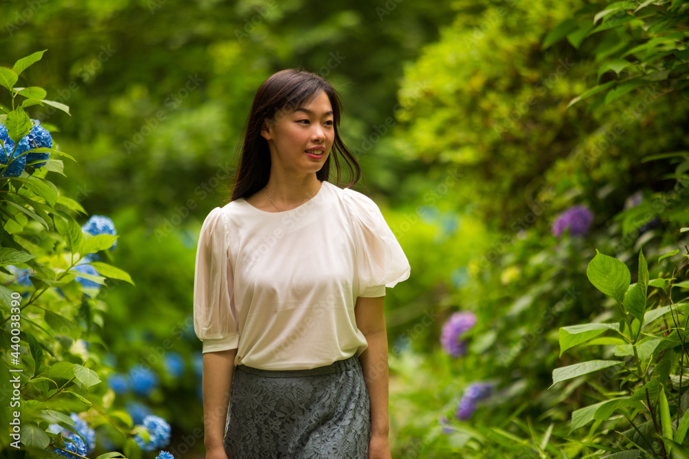 A young asian woman walking in the hydrangea garden.