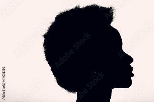 Close up profile silhouette portrait of african american woman with afro hairstyle on white studio background.