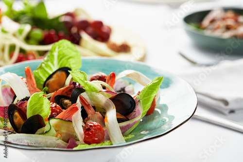 Mussels vongole in a plate with salad, mussels cooked in white wine sauce, on a party table, with white scart, salad from the chef of seafood mussels and rum leaves and lola rosa photo