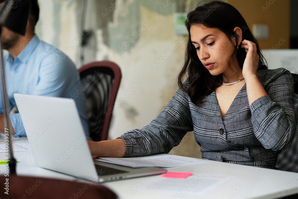 Beautiful young businesswoman working on laptop. Portrait of beautiful businesswoman in the office Beautiful young businesswoman working on laptop. Portrait of beautiful businesswoman in the office
