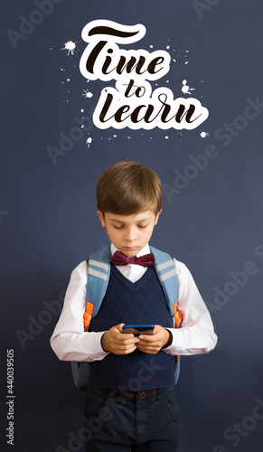 Back to school. Education. A little boy with a backpack. Schoolboy with telephone. Lettering Time to learn