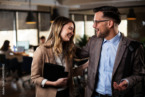 Colleagues talking in the office. Businesswoman and businessman discussing work in office