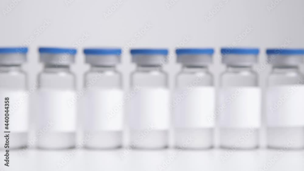 Tracking Shot Approaching Line of Vials of Translucent Liquid with Clean White Labels Tracking Shot Approaching Line of Vials of Translucent Liquid with Clean White Labels