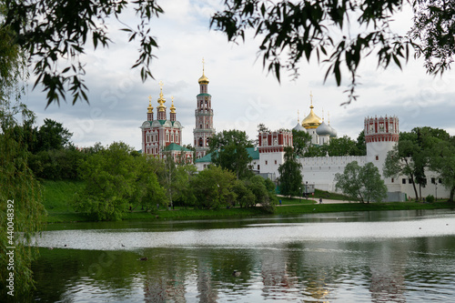 View of the Moscow Novodevichy monastery in spring evening with blurred tree leaves on the foreground