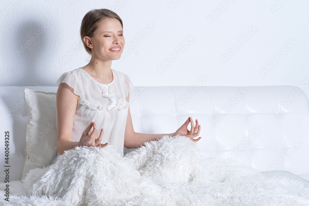 young beautiful woman in bed meditating young beautiful woman in bed meditating