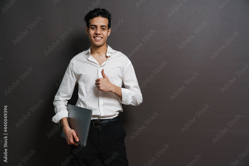 Happy mid aged brunette businessman in shirt holding laptop Happy mid aged brunette businessman in shirt holding laptop