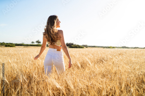 Chica guapa de moda disfrutando en un campo de trigo natural en un dia de primavera verano
