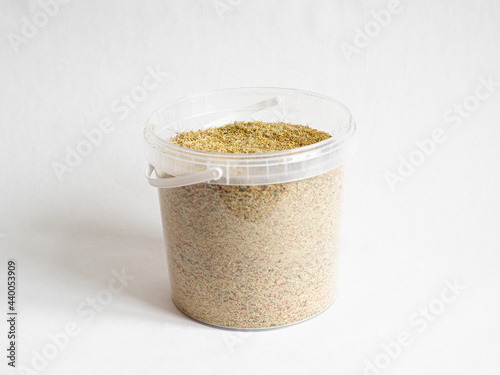 Dry sphagnum, peat moss, perennial marsh white moss of light brown beige yellow color in a transparent large bucket on white backdrop