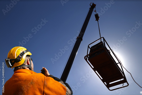 Valokuva Closeup trained competent rigger wearing safety helmet, orange long sleeve shirt