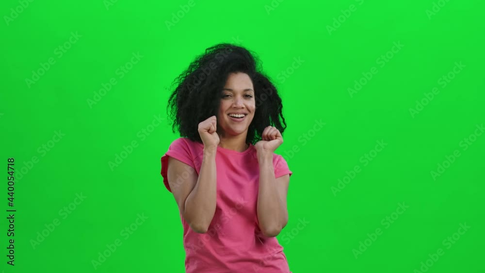 Portrait of young female African American showing thumbs up, gesture like. Black woman with curly hair poses on green screen in the studio. Close up. Slow motion ready 59.97fps. Portrait of young female African American showing thumbs up, gesture like. Black woman with curly hair poses on green screen in the studio. Close up. Slow motion ready 59.97fps.