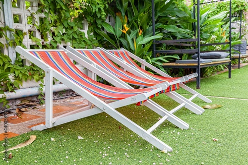 Wooden sun loungers with plastic cloth by the resort pool