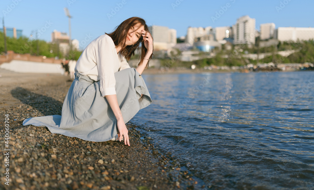 Woman in dress enjoys the sea shore. Woman in dress enjoys the sea shore.
