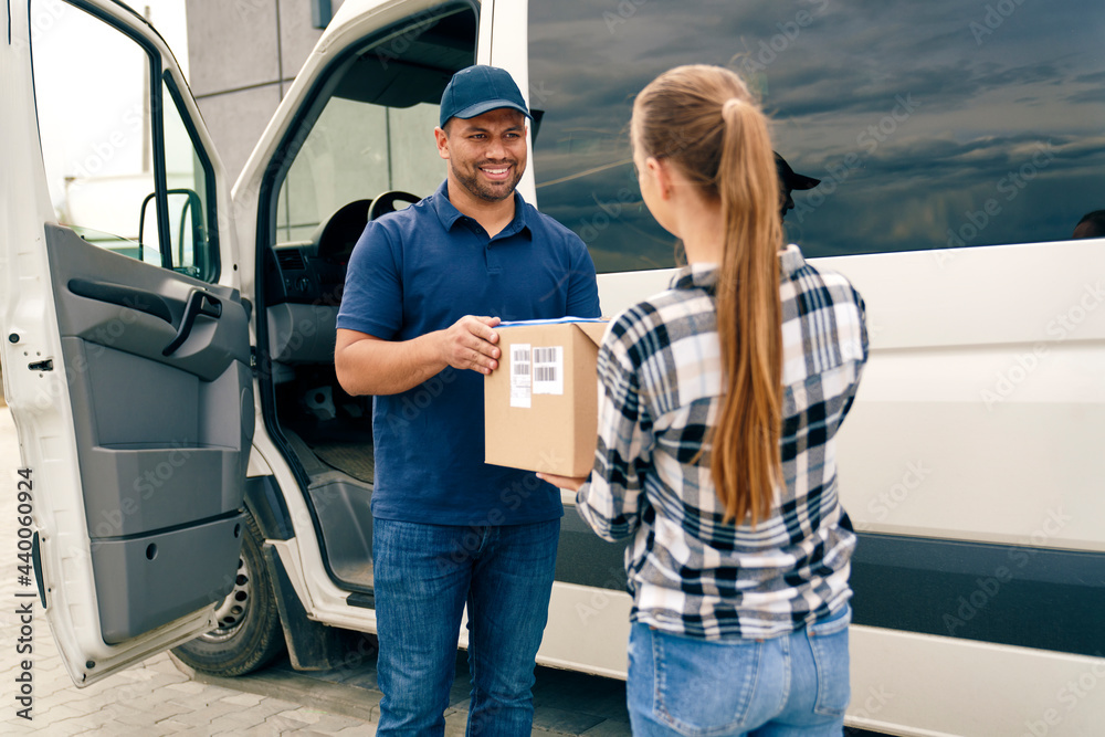 Smiling courier handing a package to a woman Smiling courier handing a package to a woman