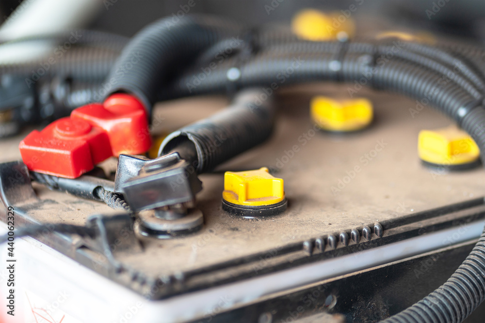 Close-up at refill distilled water inlet valve of the car battery, selective focus at the yellow cap. Transportation and vehicle part object photo. 