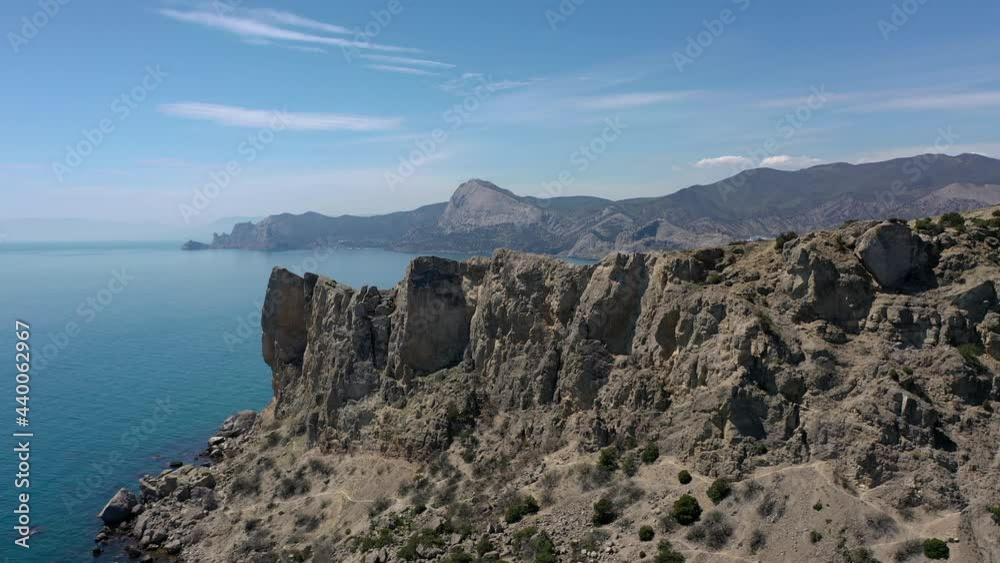 Aerial view of Mount Alchak - Kaya, Sudak Bay of the Black Sea, Sudak. Cliffed coast line cape Crimea Rocks line the shore of Black sea. Sudak area, Crimea. Aerial view of Mount Alchak - Kaya, Sudak Bay of the Black Sea, Sudak. Cliffed coast line cape Crimea Rocks line the shore of Black sea. Sudak area, Crimea.
