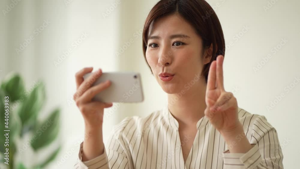 A woman studying sign language finger letters on her smartphone A woman studying sign language finger letters on her smartphone