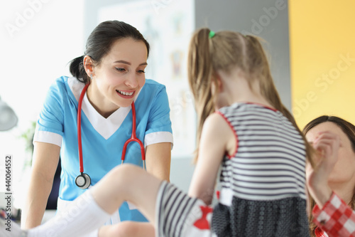 Woman doctor examining little girl at appointment in clinic