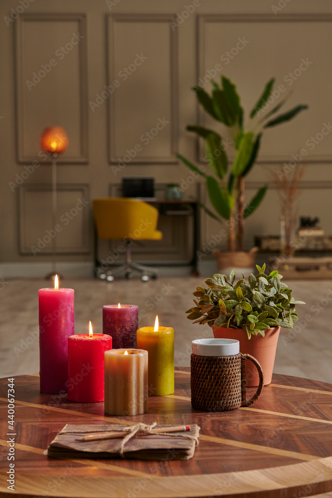 Colorful candle close up concept with coffee wicker glass on the wooden desk, decorative working table computer and chair lamp background. Colorful candle close up concept with coffee wicker glass on the wooden desk, decorative working table computer and chair lamp background.