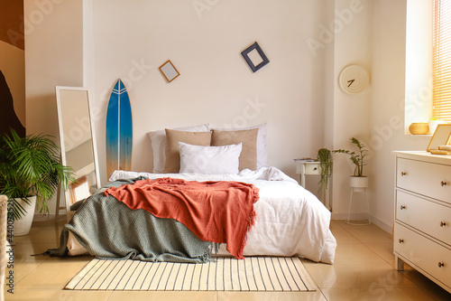 Interior of modern bedroom with surfboard