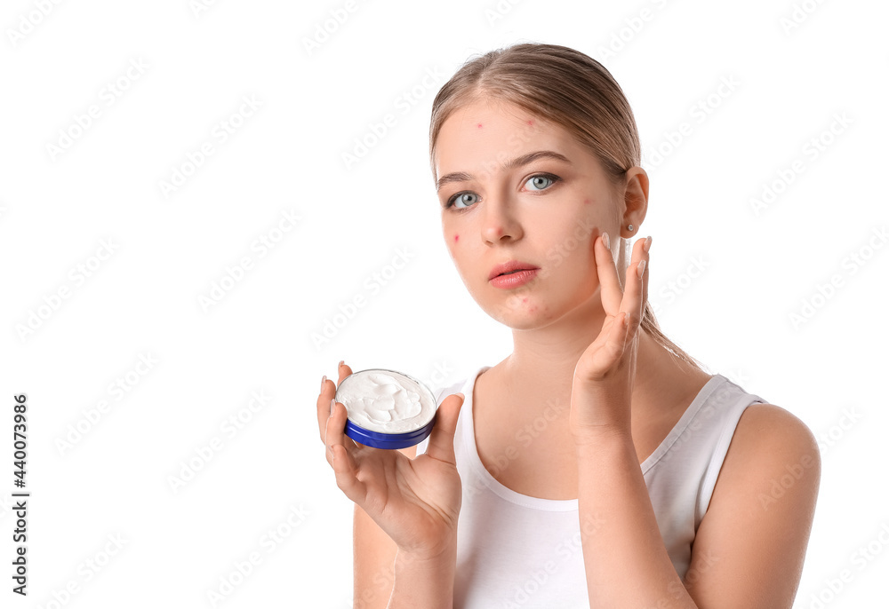 Teenage girl applying remedy for acne against white background Teenage girl applying remedy for acne against white background