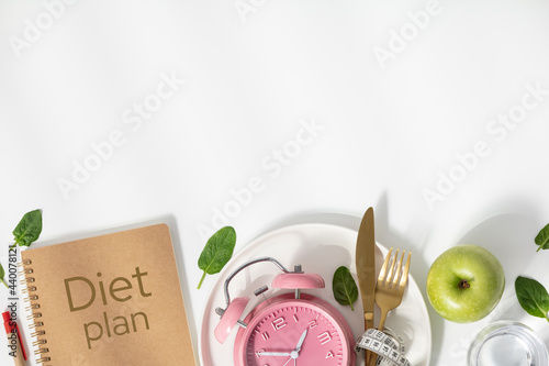 Composition with cutlery, measuring tape, diet plan and alarm clock on color background. Diet concept, copy space