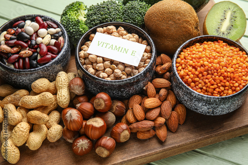 Board with healthy products rich in vitamin E on color wooden background, closeup © Pixel-Shot