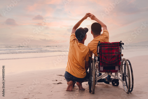 Foto Asian special child on wheelchair on the beach with parents in family holiday to travel, exercise and learning about nature around the sea beach, Life in the education age, Happy disabled kid concept