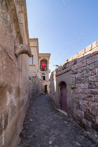 Architect Mimar Sinan's old house with a Turkish flag at Agirnas, Kayseri, Turkey under a blue sky photo