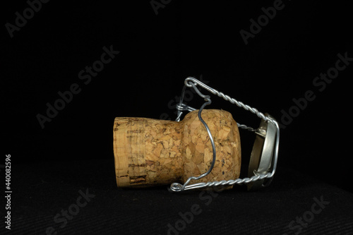sparkling wine cork inside a wire cage isolated on a black background