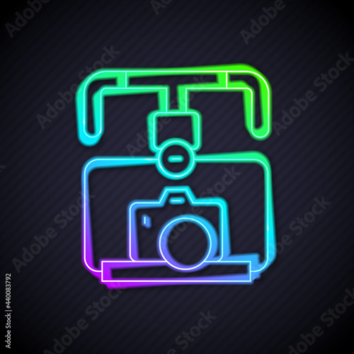 Glowing neon line Gimbal stabilizer with DSLR camera icon isolated on black background. Vector