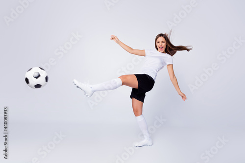 Full length photo of excited captain lady player soccer women team kicking leg leather ball wear football uniform t-shirt shorts boots knee socks isolated white color background © deagreez