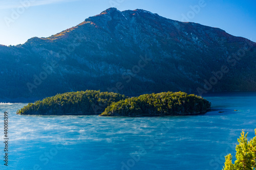 Aerial view of the Mascardi Lake surrounded by mountains under the blue sky