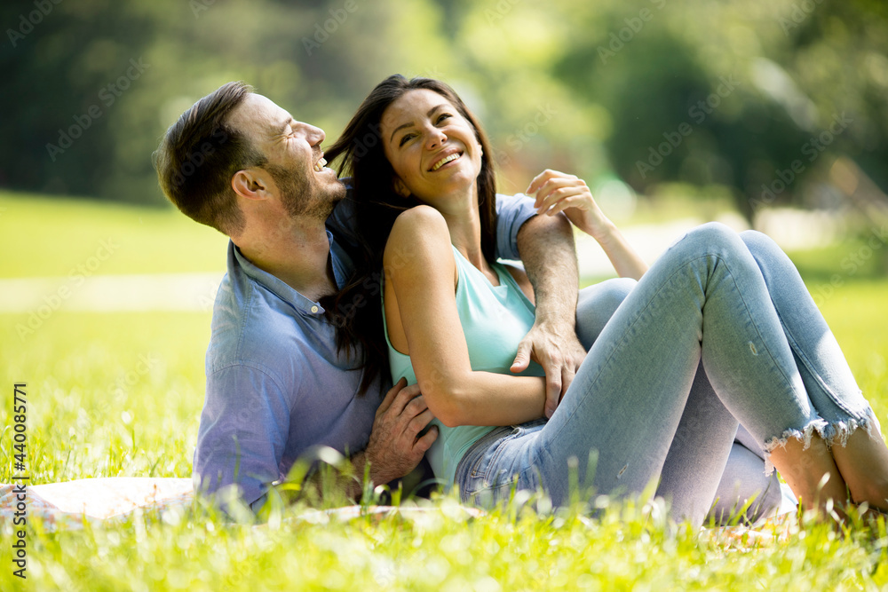 Affectionate young couple sitting on the green grass Affectionate young couple sitting on the green grass