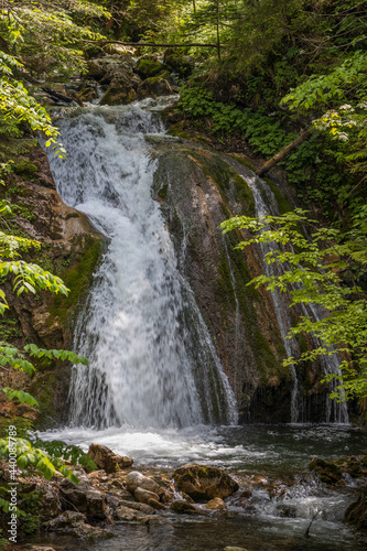 Wasserfall im Wald mit steinigem Flussbett