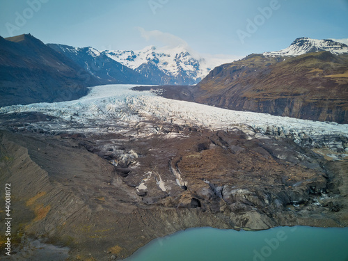 Iceland's Skaftafell Glacier on a rare clear day brings out the details in the blue ice and eons of accumulated dirt and grime with the snow capped mountains in the background © Jorge Moro