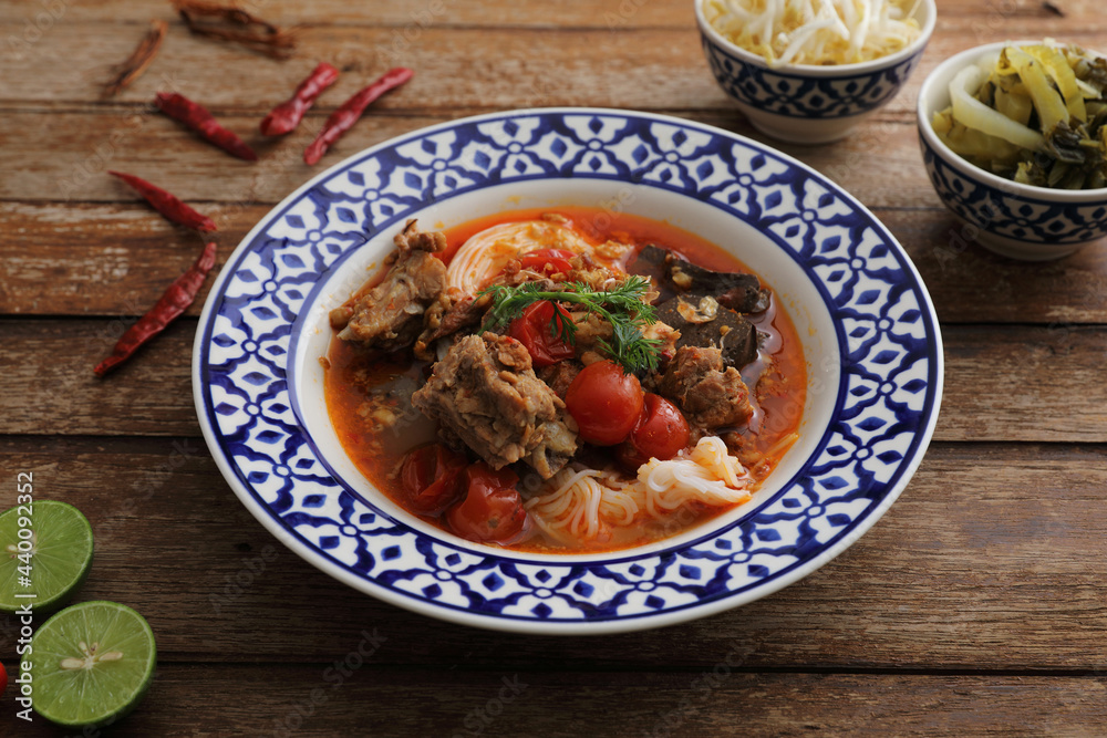 Local northern thai food Rice noodles with pork in spicy soup in wood background Local northern thai food Rice noodles with pork in spicy soup in wood background