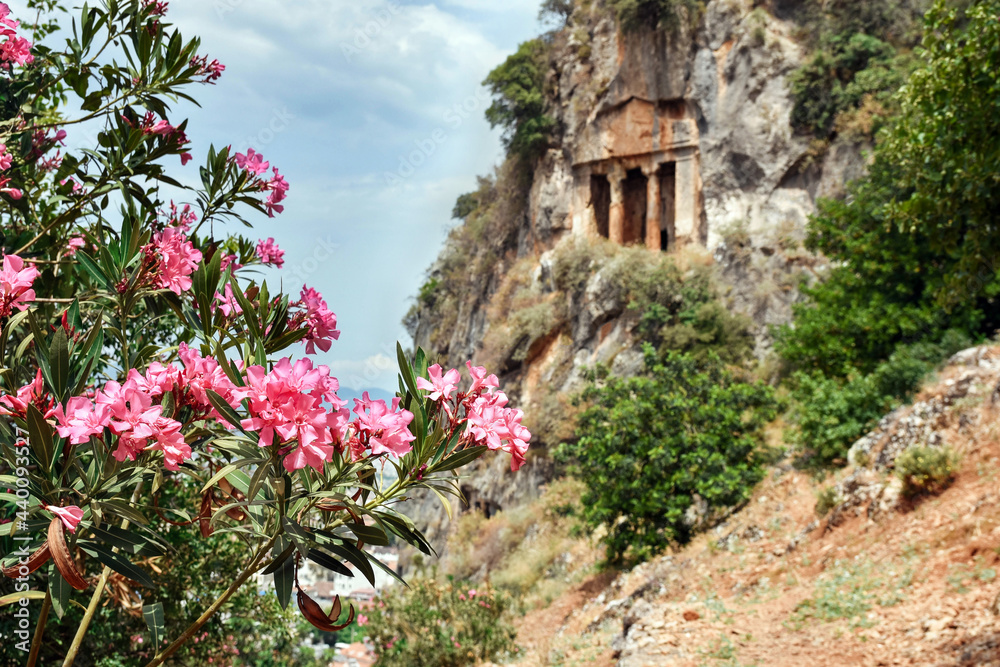 Lycian tombs in the Turkish city of Fethiye. The tombs of Amintas carved into the rock rise above the city, and in the distance a panorama of the city and the mountains.