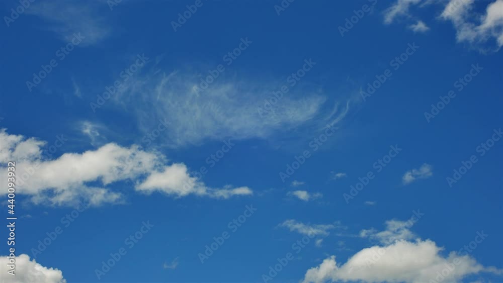 The motion of White Fluffy Clouds In Blue Sky. Time-Lapse of Beautiful blue sky on a summer day with white cumulus The motion of White Fluffy Clouds In Blue Sky. Time-Lapse of Beautiful blue sky on a summer day with white cumulus