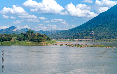 Beautiful landscape of Kaeng Khut Khu (set of islets in the middle of Mae Khong River) with mountain, Mekong river and cloudy blue sky at Chiang Khan district, Loei province, Thailand photo