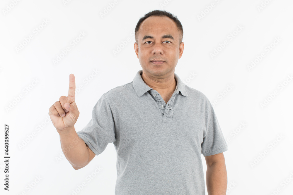 Portrait of middle age senior Asian man in a light grey cloth raising and showing one finger. Isolate on white background. Portrait of middle age senior Asian man in a light grey cloth raising and showing one finger. Isolate on white background.