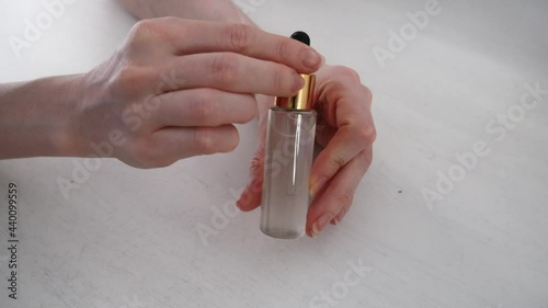 female hands take out cosmetic serum from the bottle