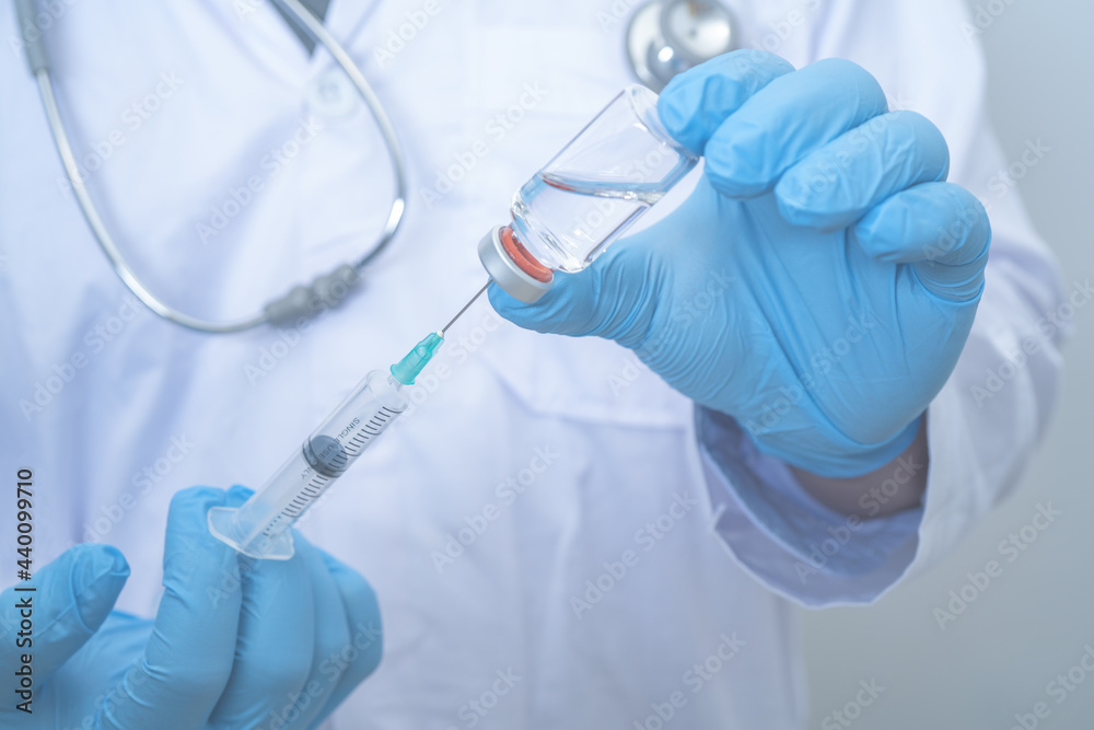 Male Doctor wearing PPE with a stethoscope on shoulder and holding syringe COVID-19 vaccine CORONA vaccine concept Healthcare and Medical Male Doctor wearing PPE with a stethoscope on shoulder and holding syringe COVID-19 vaccine CORONA vaccine concept Healthcare and Medical