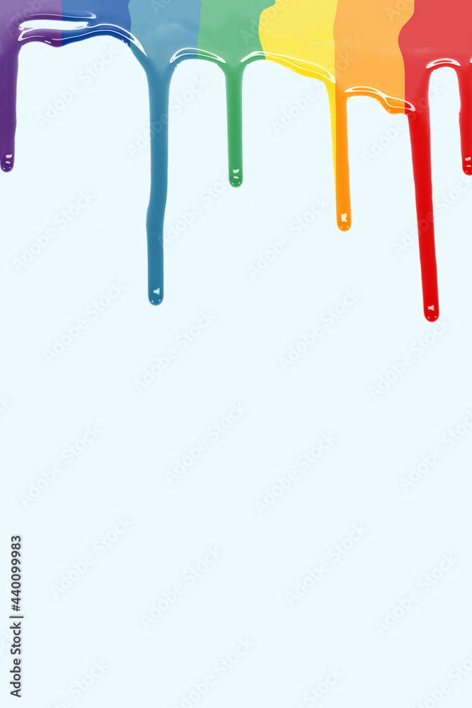 Drops of paint falling as LGBT flag in a blue background. paint rainbow. vertical image with copy space. Drops of paint falling as LGBT flag in a blue background. paint rainbow. vertical image with copy space.