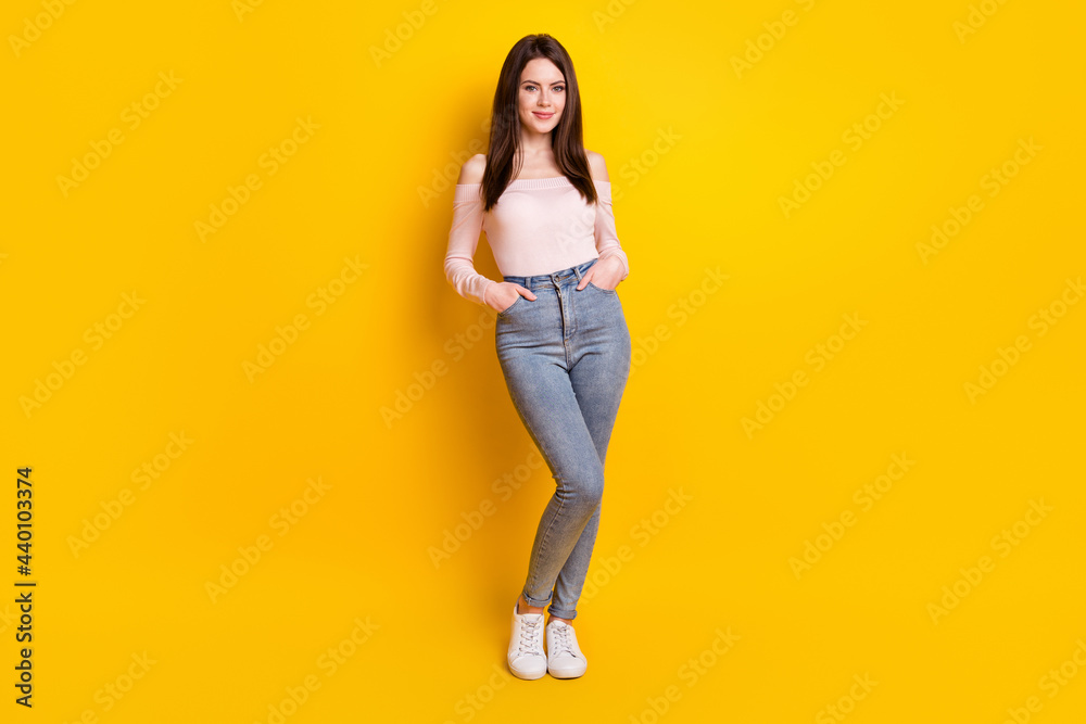 Full size photo of happy positive smiling beautiful gorgeous woman hold hands pockets isolated on yellow color background